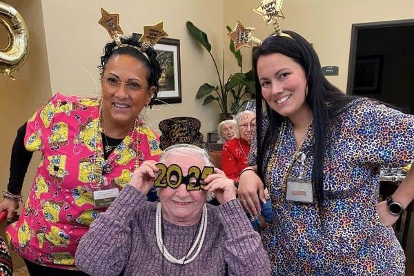 Staff and residents celebrating New Year's with props