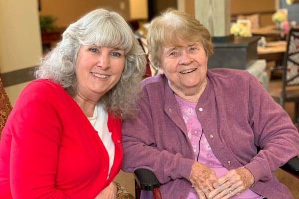 A staff member with a resident smiling together