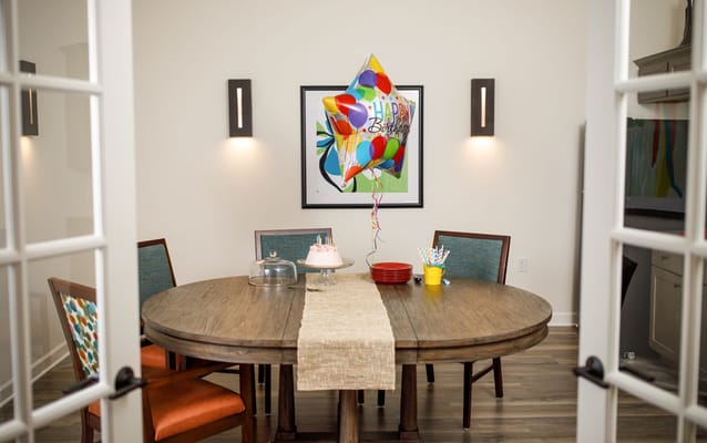 Brightly decorated dining room with a celebratory cake.