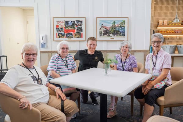 Residents and staff enjoying time together at a communal table