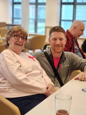 Resident and staff member smiling together in a communal space