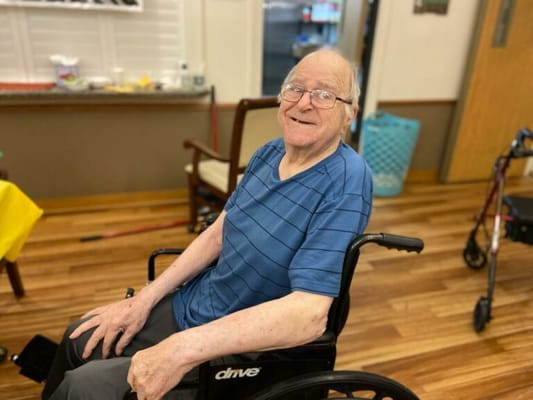 Smiling resident in a wheelchair in a common area