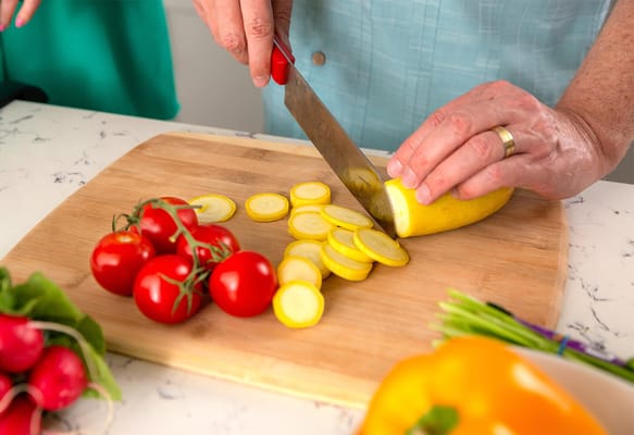 Hands preparing fresh vegetables on a cutting board