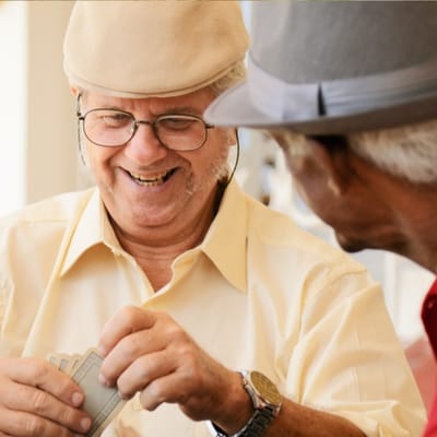 Two seniors engaged in a card game indoors