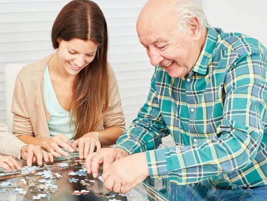Residents and staff enjoying puzzle activity together