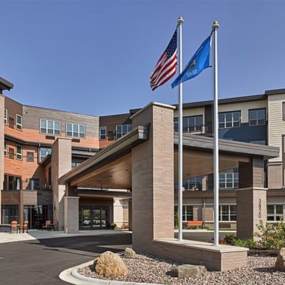 Entrance view of Cardinal View Senior Living with flags