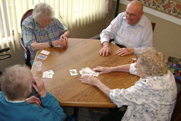 Residents playing cards around a table