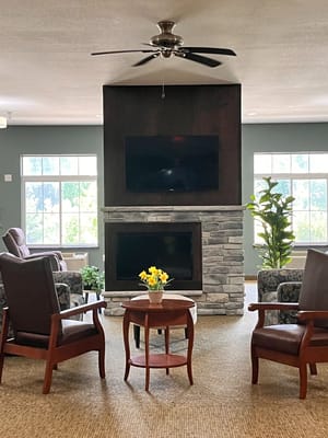 A cozy common area with comfortable seating and a fireplace