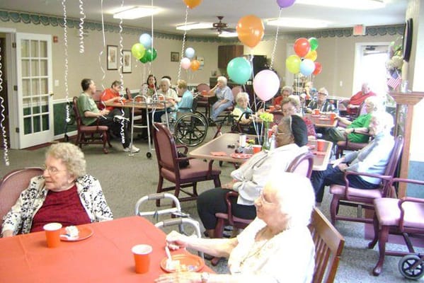 Residents celebrating with balloons and refreshments in a common area