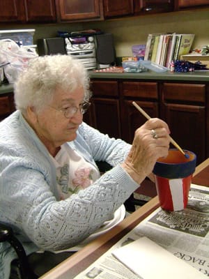 Resident painting a flower pot in a common area