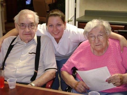 Two residents and a staff member in a common area