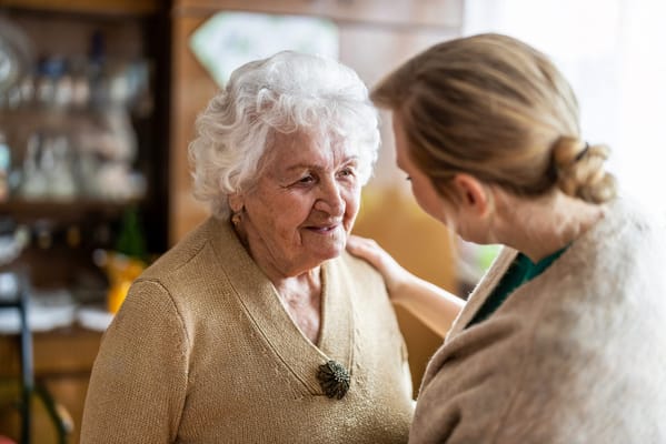 Senior woman smiling while interacting with staff