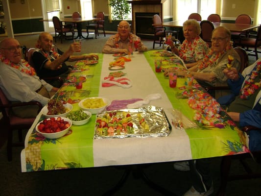 Seniors enjoying a festive meal with tropical drinks
