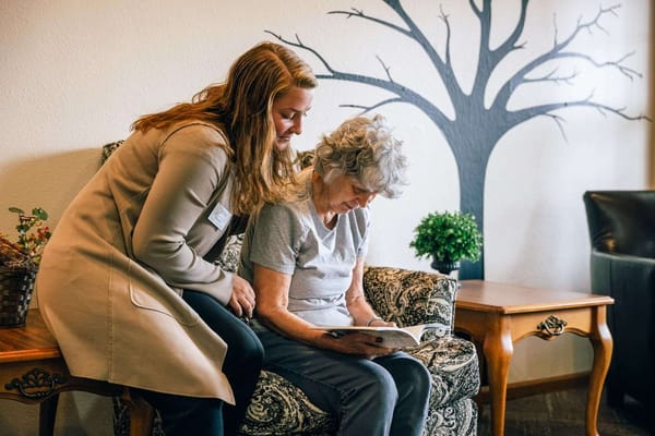 Staff member assisting a resident in a cozy sitting area