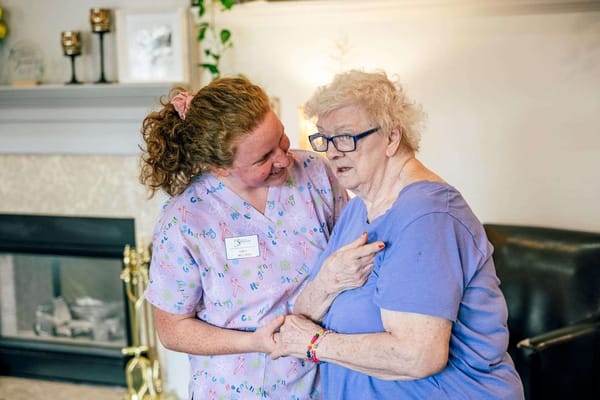 Staff member assisting a resident in a cozy indoor setting