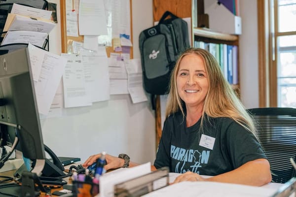 Staff member smiling at her desk in the administrative area