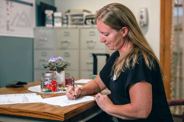 Staff member assisting with paperwork at a desk