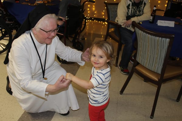A resident interacting with a young child at an event