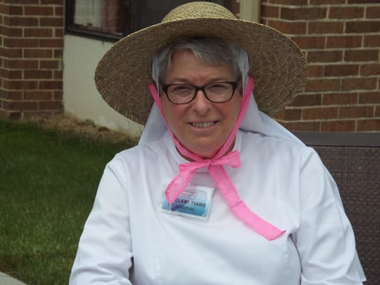 Staff member in a hat and name badge outdoors