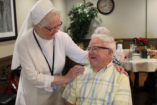 A staff member interacting with a resident in a cozy common area