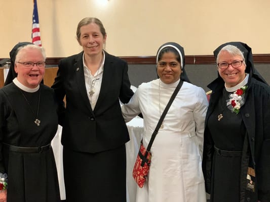 Four staff members smiling together at an event