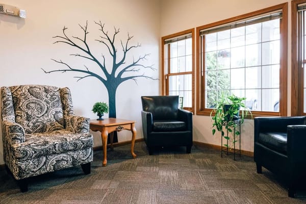 Cozy seating area with stylish chairs and a tree mural