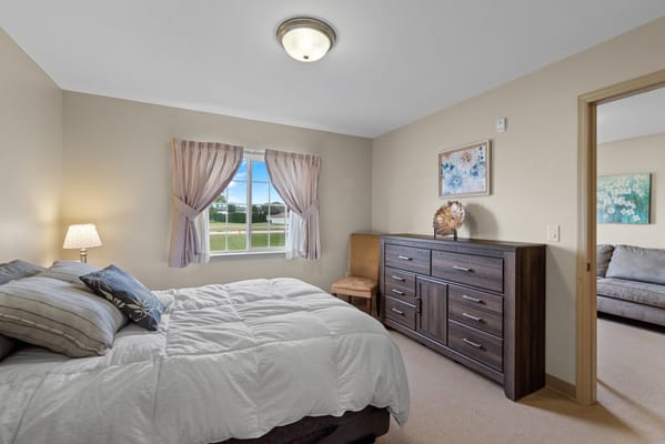 A cozy resident room with a bed and dresser