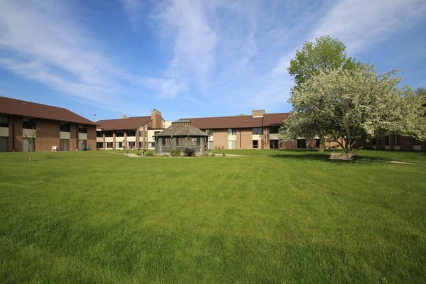 Exterior view of St Monicas Senior Living campus with lawn and trees