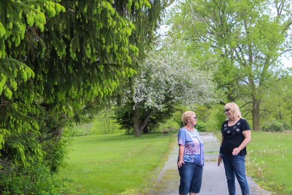 Two residents chatting on a path with greenery