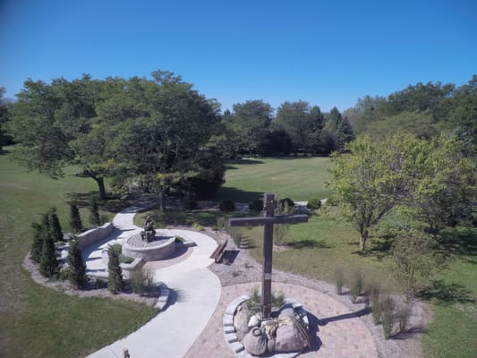 Aerial view of a landscaped outdoor area with a cross