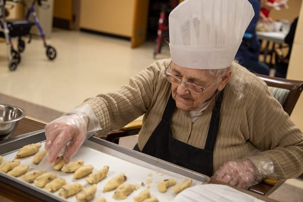 Senior resident baking cookies in the activity room