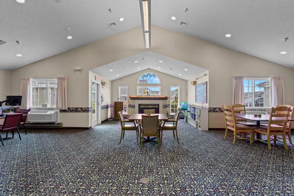 Common area with tables and chairs in a light-filled room