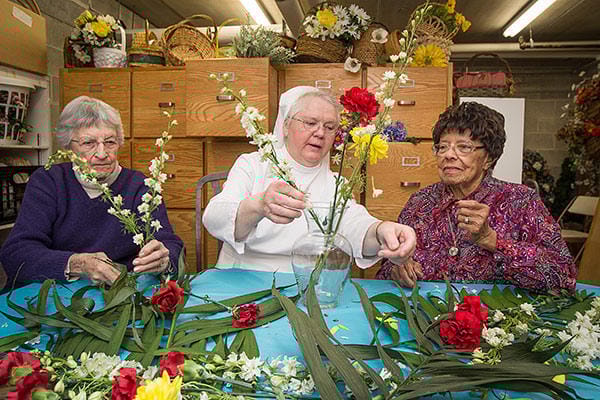 Residents and staff arranging flowers during an activity