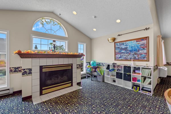Bright common area with fireplace and activity supplies