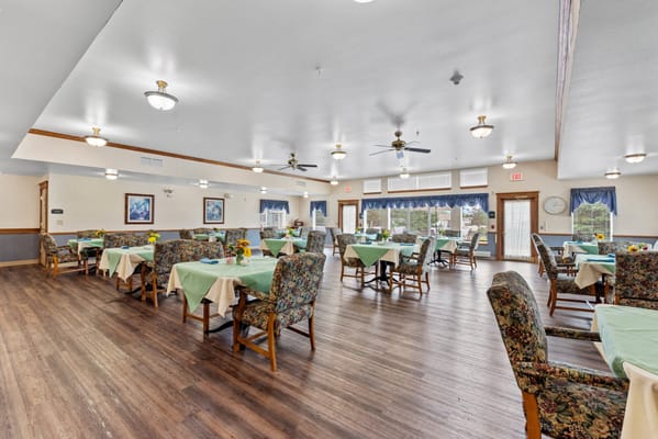 Bright dining room with floral tablecloths and chairs