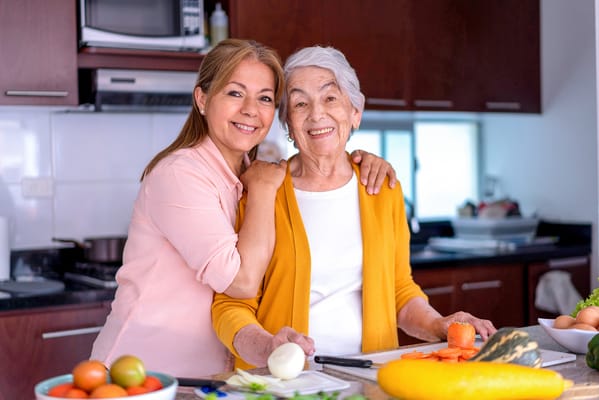 A caregiver and an elderly resident in a kitchen