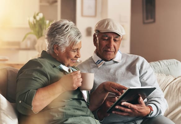 Couple enjoying time together on a couch with a tablet