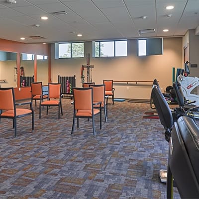 An activity room with chairs and exercise equipment