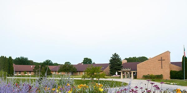 Exterior view of St Monicas Senior Living facility with flowers