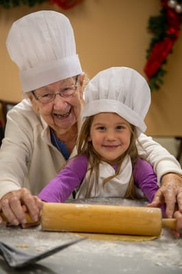 Elderly woman and girl baking together in a kitchen