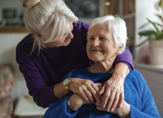 Nurse embracing an elderly resident in a cozy interior