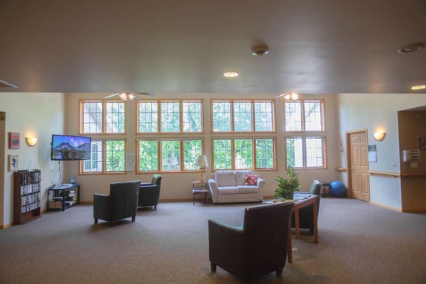 Bright common area with large windows and seating