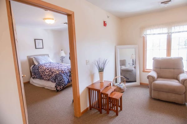 Private resident room with bed and comfortable seating