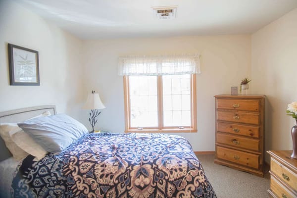 Cozy private bedroom with a window and wooden furniture