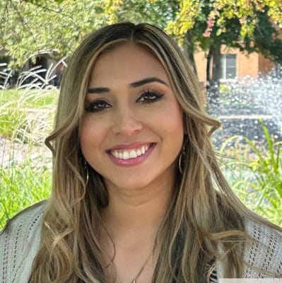 A smiling woman outdoors in a garden setting