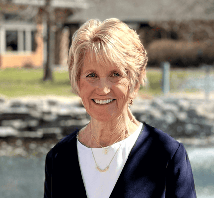 Smiling resident by a pond in an outdoor space