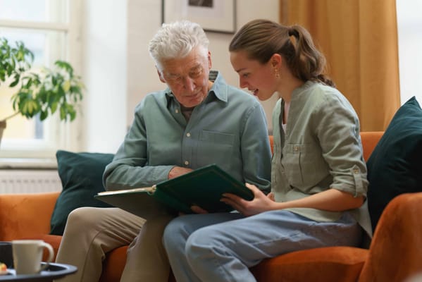 Senior resident and staff member looking at a photo album