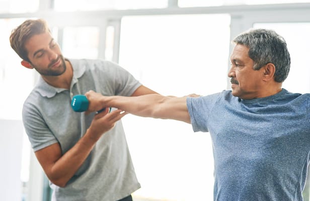 A staff member assisting a resident with exercise