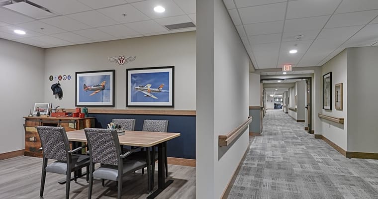 Bright common area with a table and art on the walls
