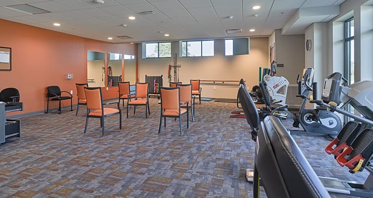 Bright fitness area with exercise equipment and chairs